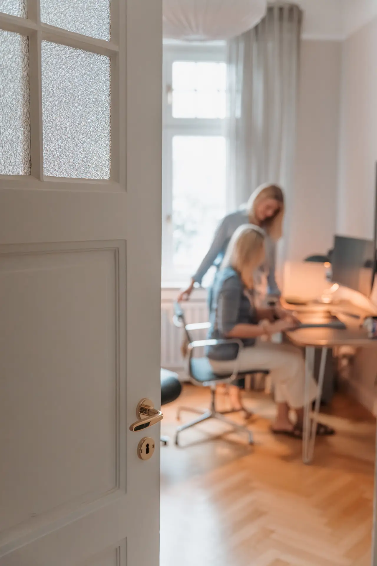 Zwei Frauen vor Schreibtisch bereiten Immobilienverkauf in Düsseldorf vor